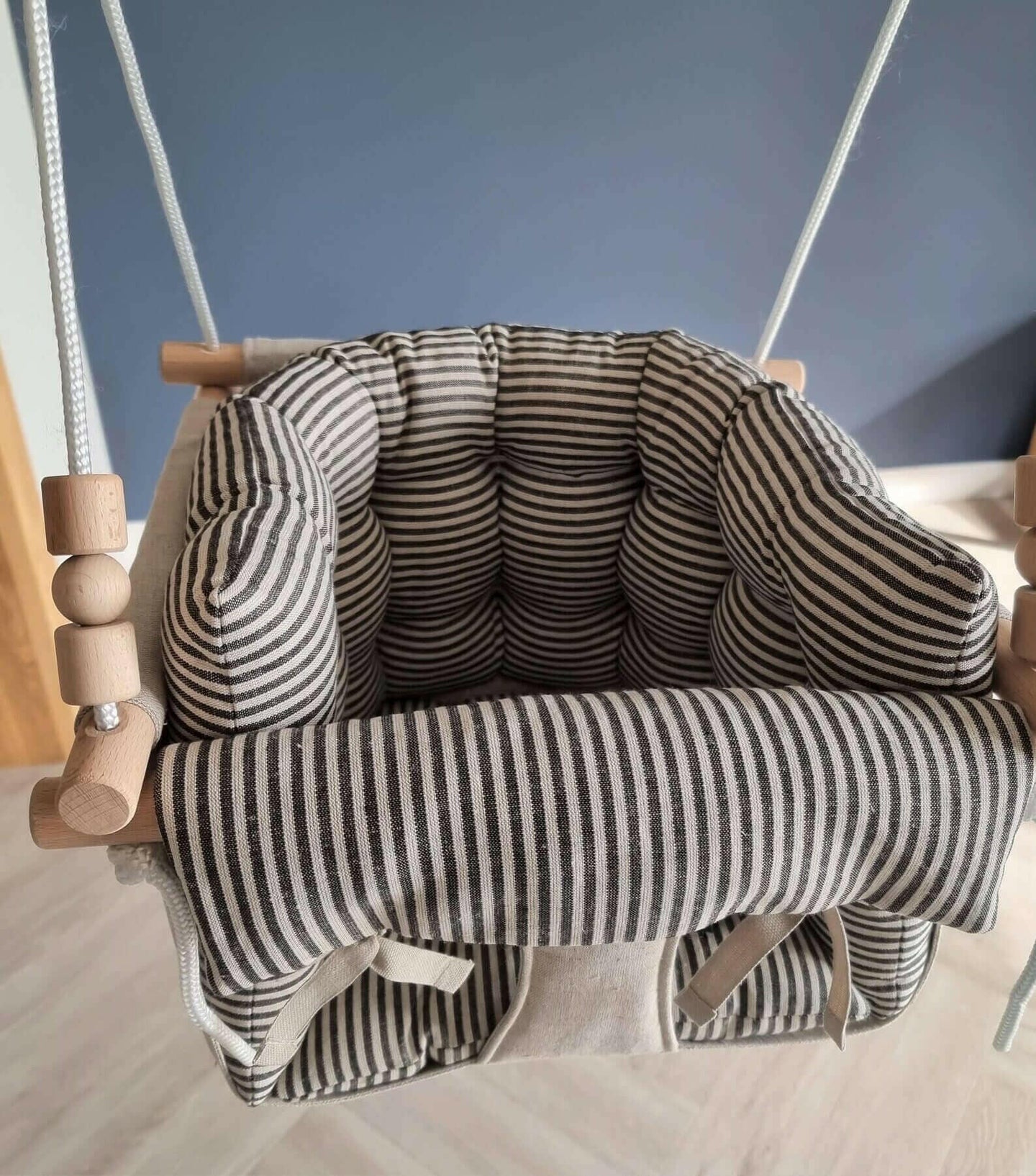 Premium Babyschaukel aus Leinen mit schwarzen Streifen.