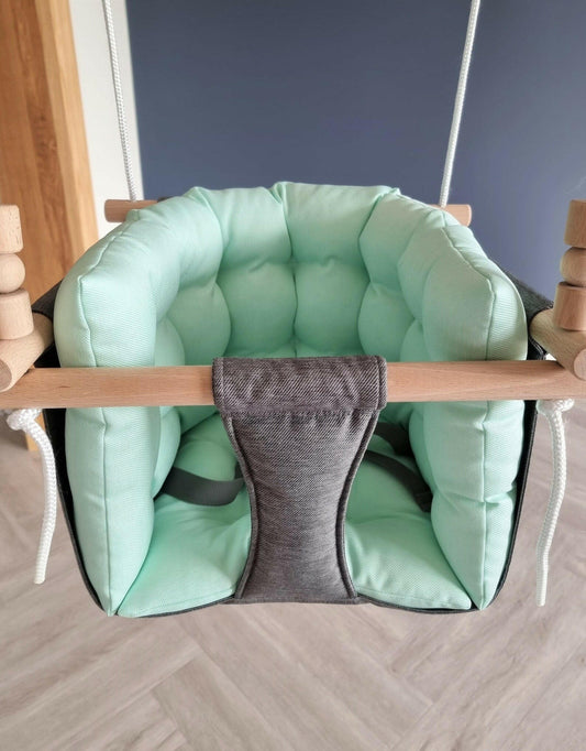 Premium Babyschaukel aus Polyester, Dunkelgrau mit mintgrünem Kissen.