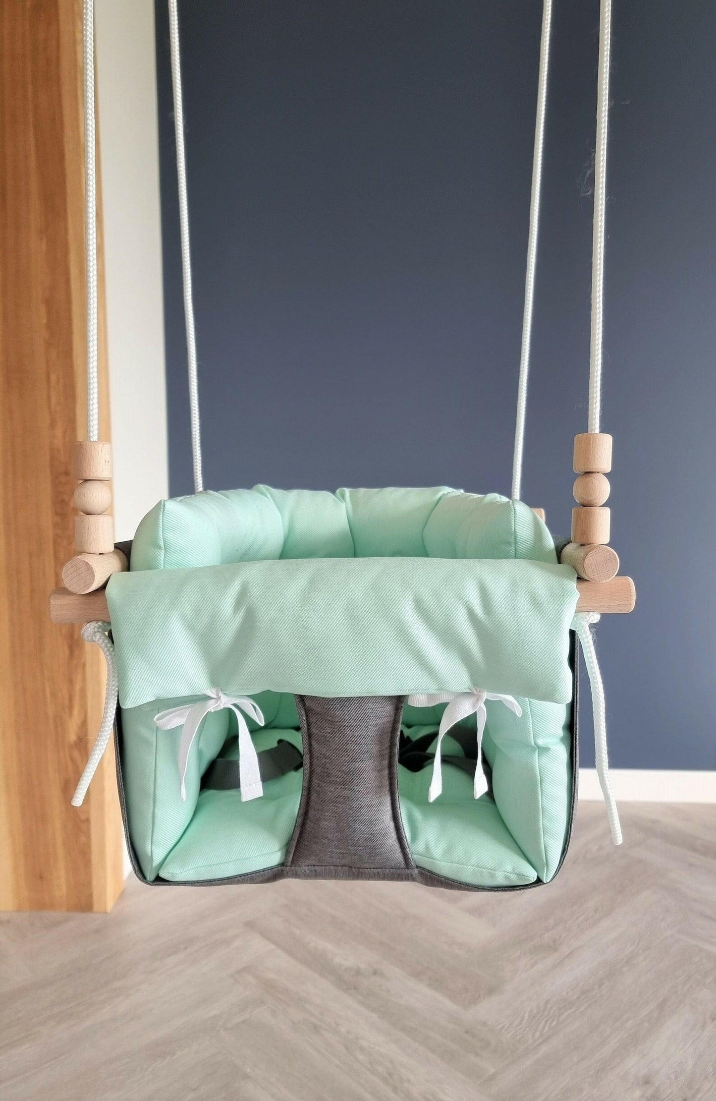 Premium Babyschaukel aus Polyester, Dunkelgrau mit mintgrünem Kissen.