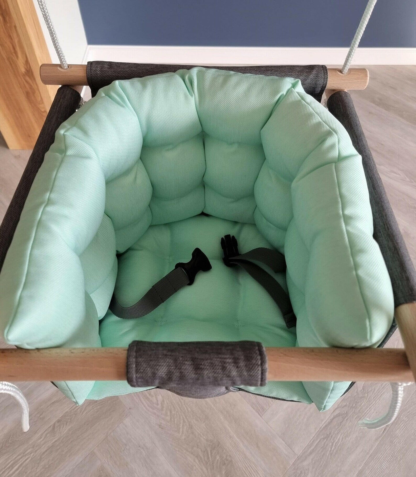 Premium Babyschaukel aus Polyester, Dunkelgrau mit mintgrünem Kissen.