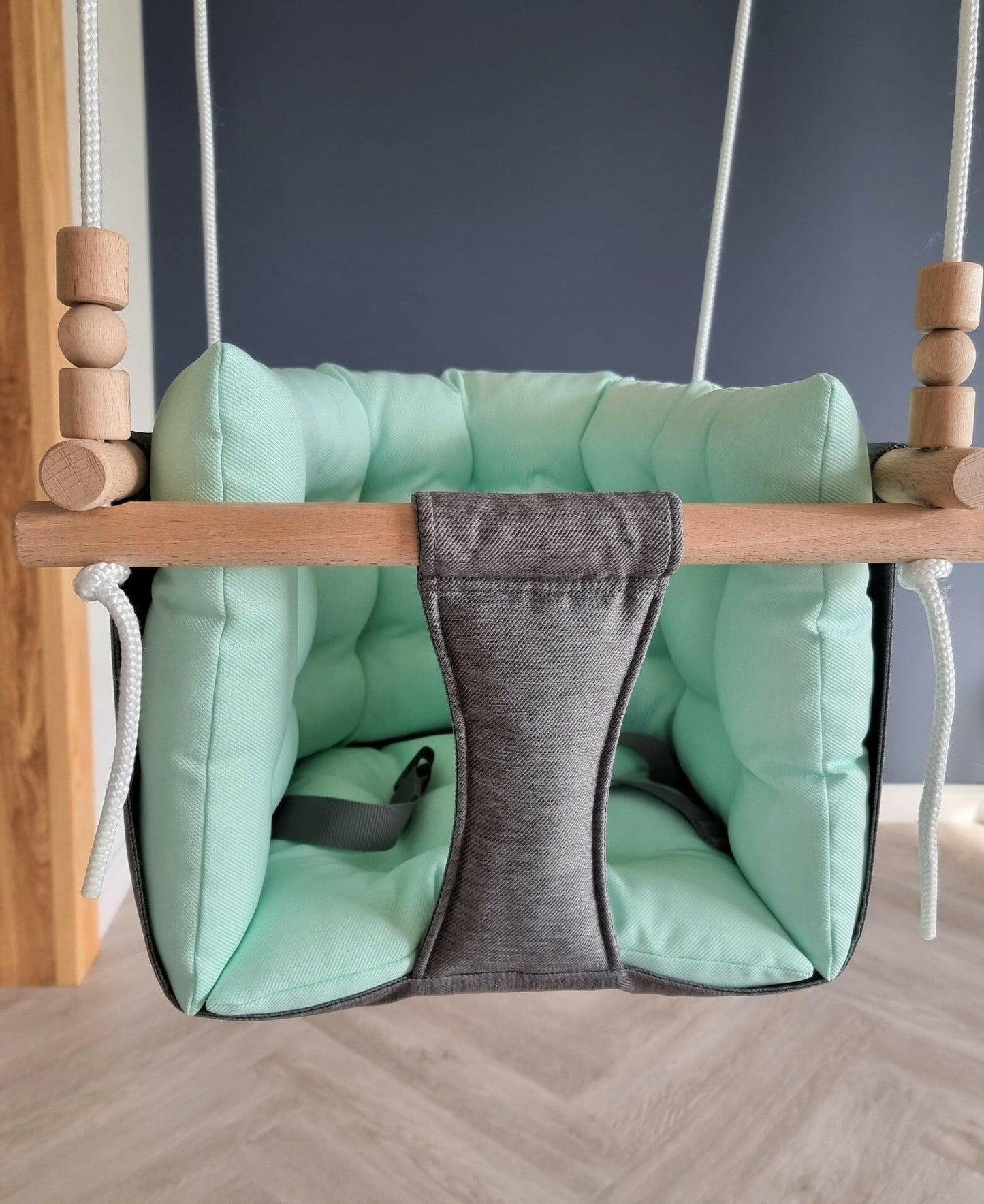 Premium Babyschaukel aus Polyester, Dunkelgrau mit mintgrünem Kissen.