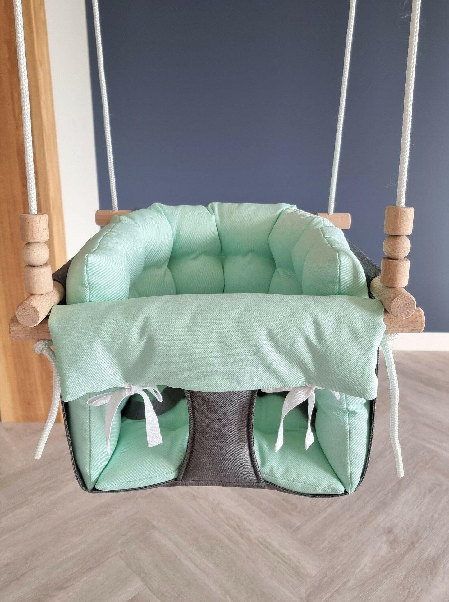 Premium Babyschaukel aus Polyester, Dunkelgrau mit mintgrünem Kissen.